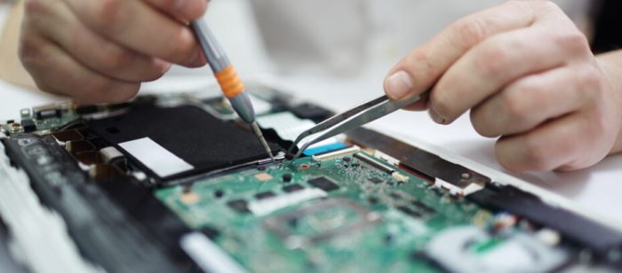 Assembling Electronic Circuit Board Closeup shot of male hands working on assembling new circuit board using tweezers and screwdriver
